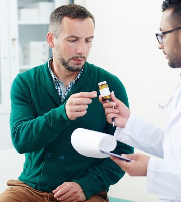 Doctor prescribing pills or vitamins to patient during medical consultation